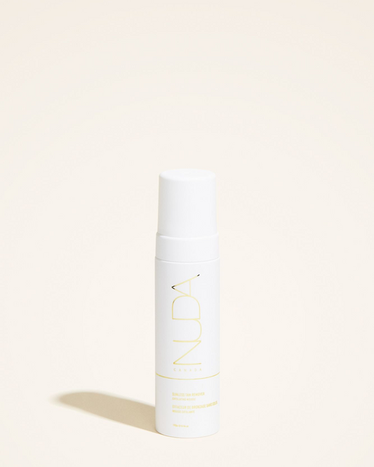 Sunless Tan Remover mousse bottle, featuring a sleek design with white and yellow branding on a neutral background.