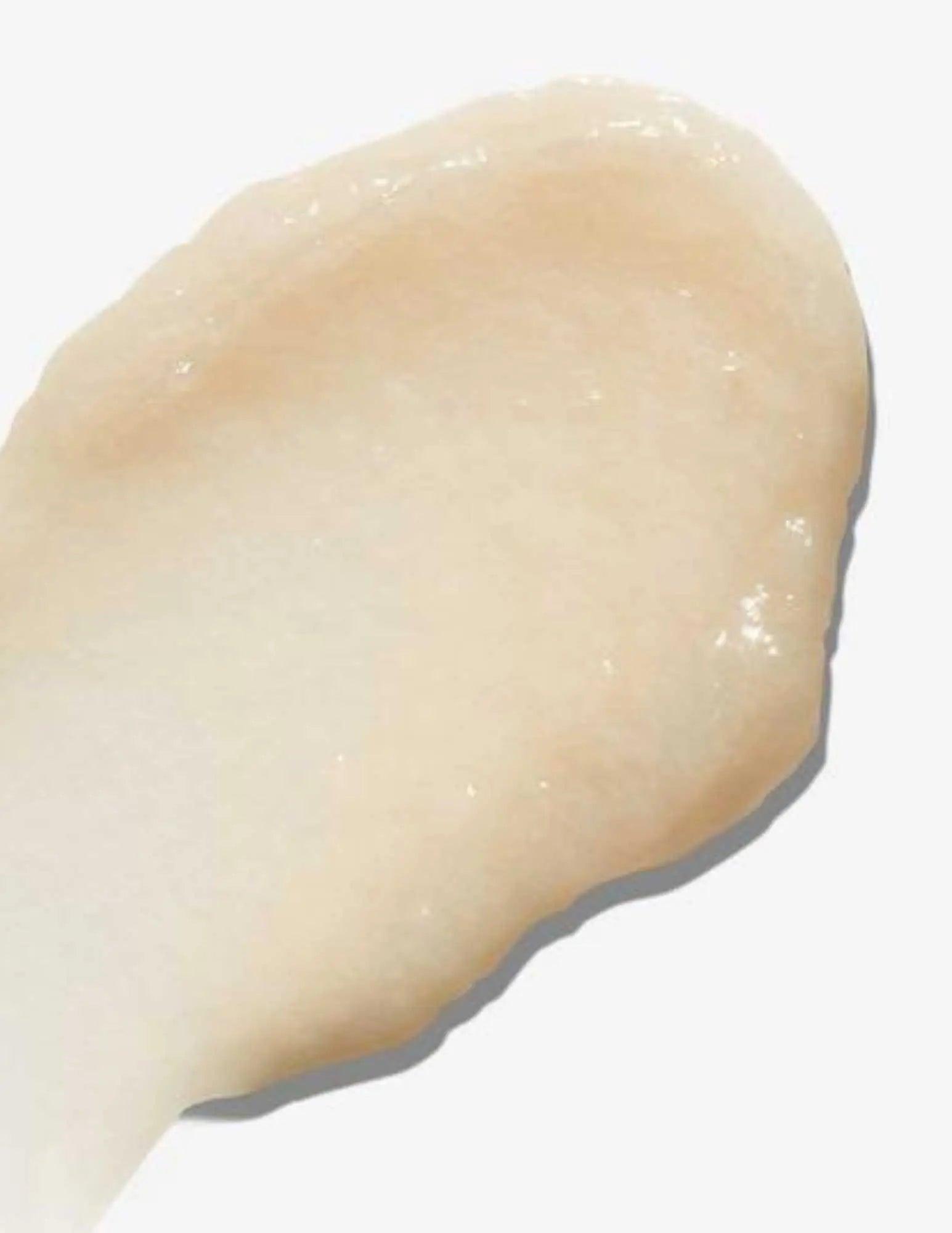 creamy texture of Redken All Soft Mega Curls Conditioner on a white background, ideal for enhancing and hydrating curls.