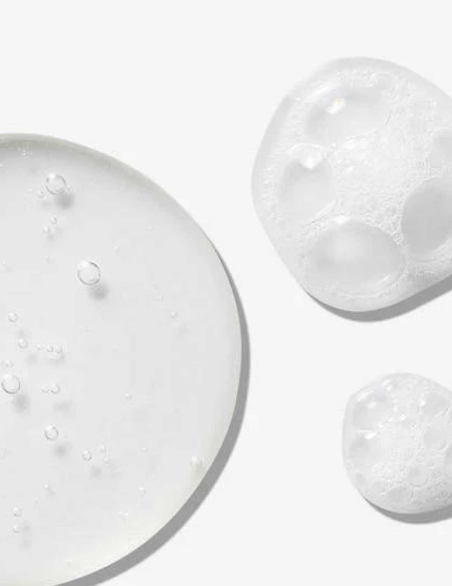 Close-up of clear gel droplets and bubbles, showcasing the hydrating formula of Redken All Soft Mega Curls Shampoo.