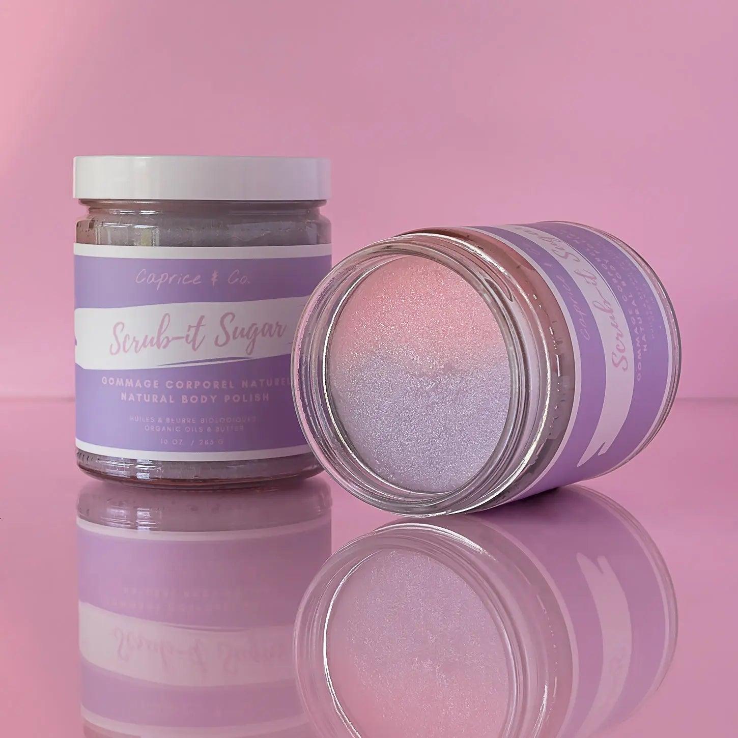 Natural sugar scrub in jars with purple labels, showcasing the bubblegum scent and moisturizing properties, set against a pink background.