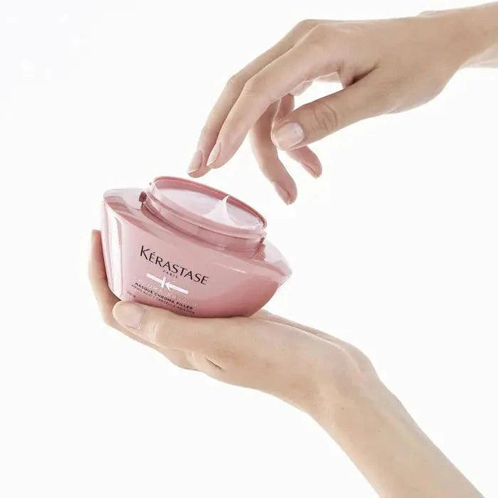 Hands holding Kerastase hair product jar for enhancing hair care and smoothness