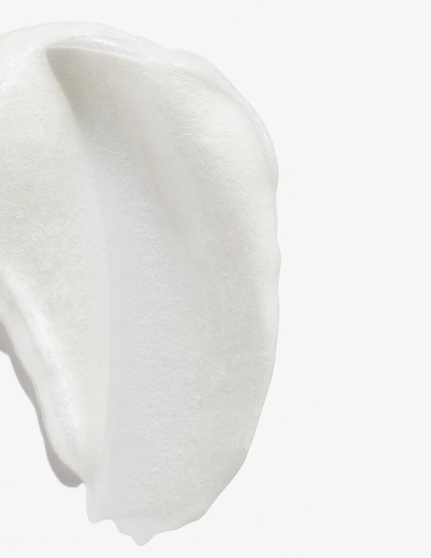 Close-up of a creamy, white texture resembling the Redken Color Extend Magnetics Conditioner.