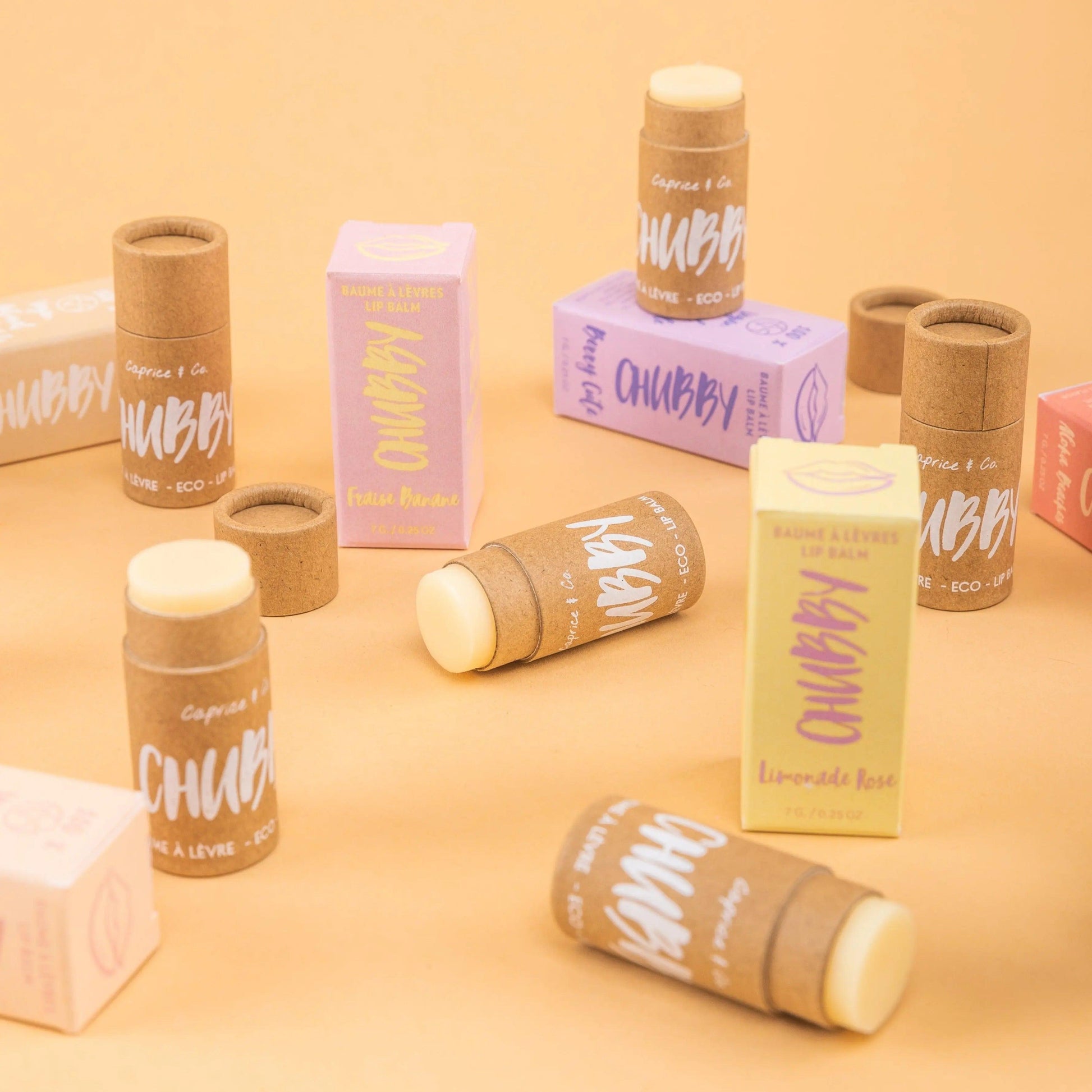eco-friendly compostable vegan lip balms in colorful packaging on an orange background. Handmade and organic.
