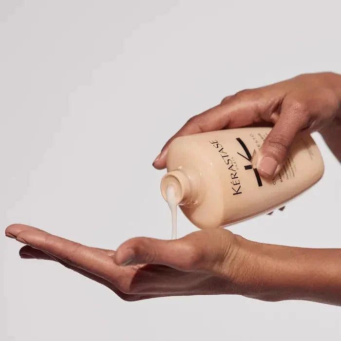 Kerastase Curl Manifesto Bain Hydration Douceur shampoo being poured into a hand, ideal for curly and coily hair care.
