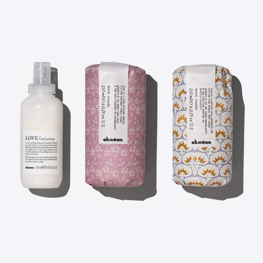 Davines Defined Waves Set featuring Love Curl Primer, Curl Building Serum, and Medium Hold Modeling Gel for bouncy waves.