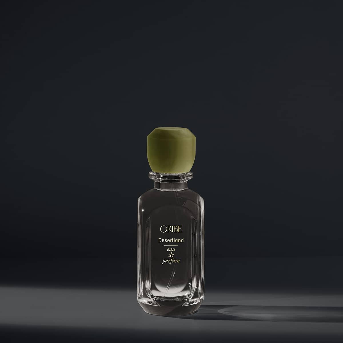 Oribe Desertland eau de parfum bottle against a dark background.