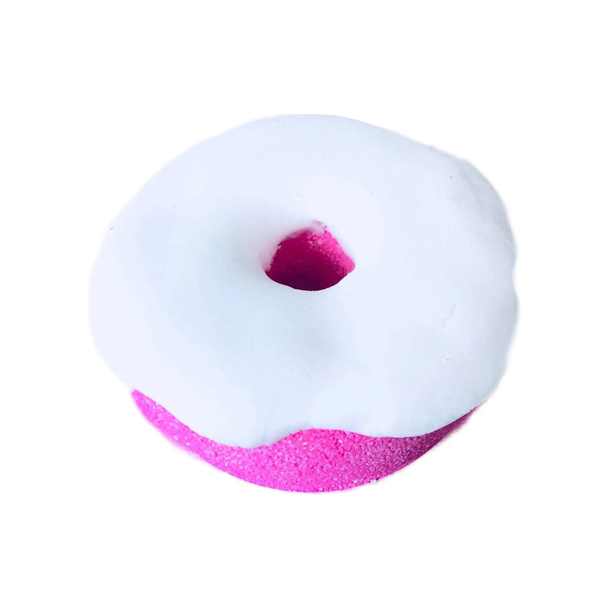 Pink donut-shaped bath bomb with white icing, infused with marshmallow cake scent, perfect for a soothing bath experience.