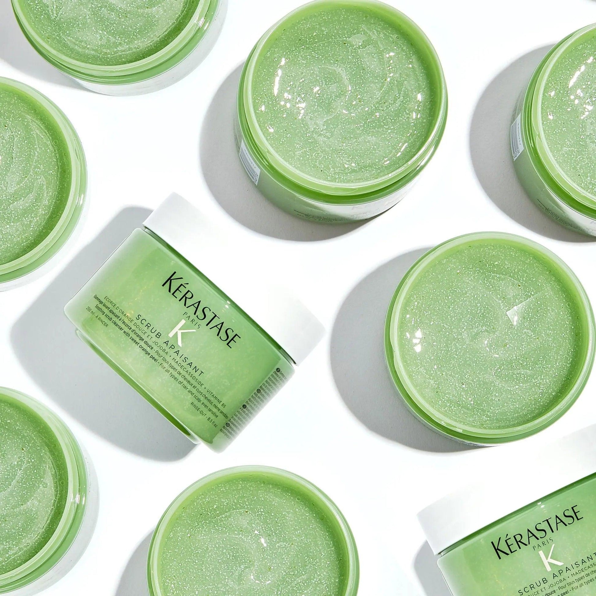 Kérastase green hair scrub in jars with shiny texture, displayed on white background.