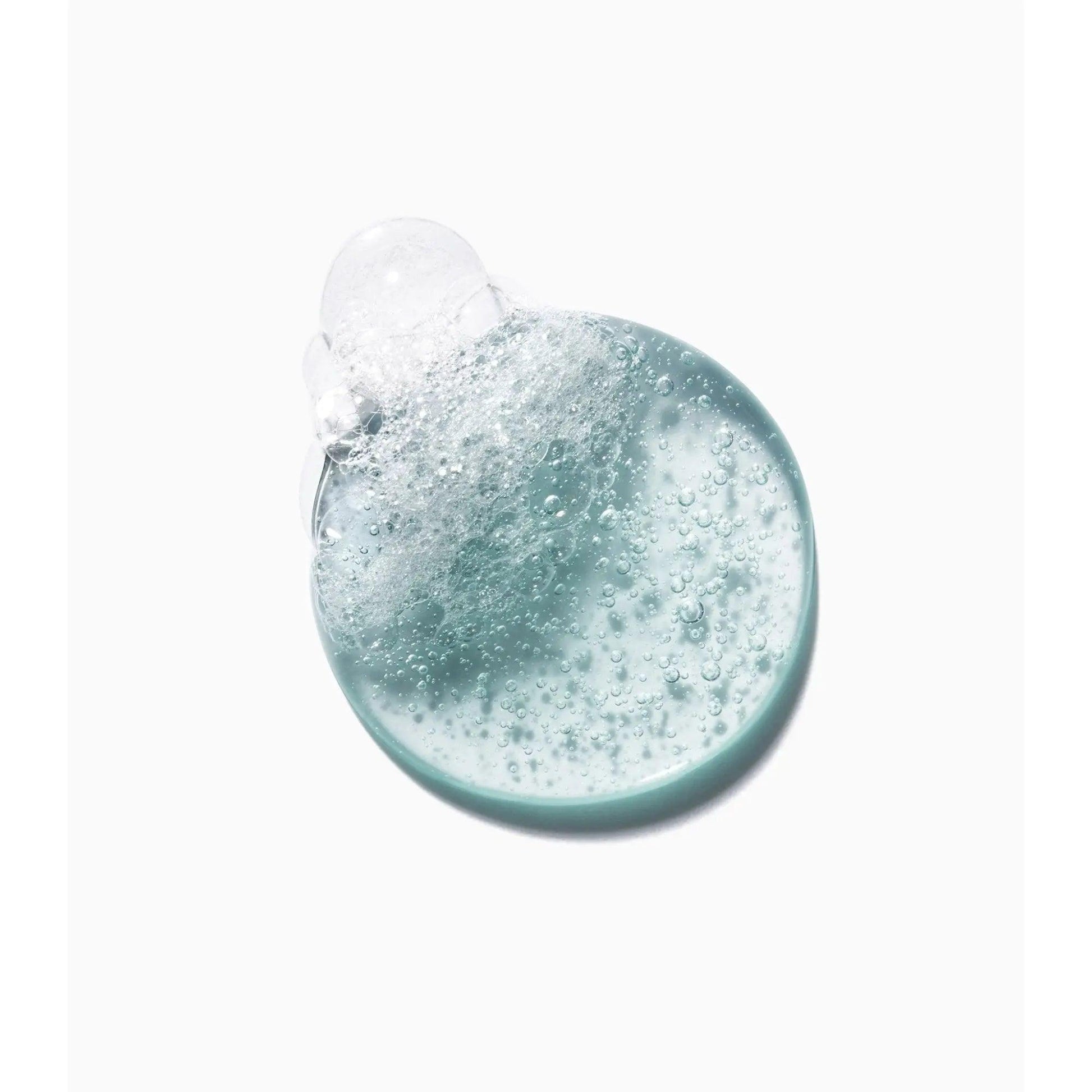 Blue bubbling gel texture from Kérastase Genesis Homme Bain de Force Quotidien Shampoo showcasing its refreshing formula.