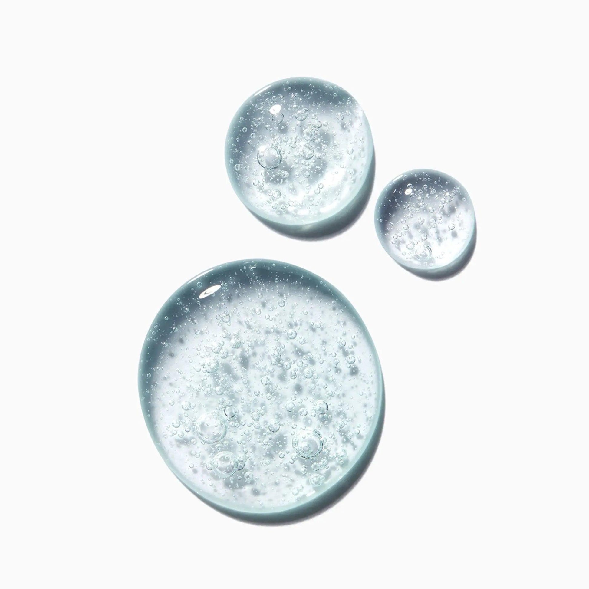 Clear gel droplets with bubbles, showcasing the texture of Kérastase Genesis Homme Bain De Masse Épaississant Shampoo.