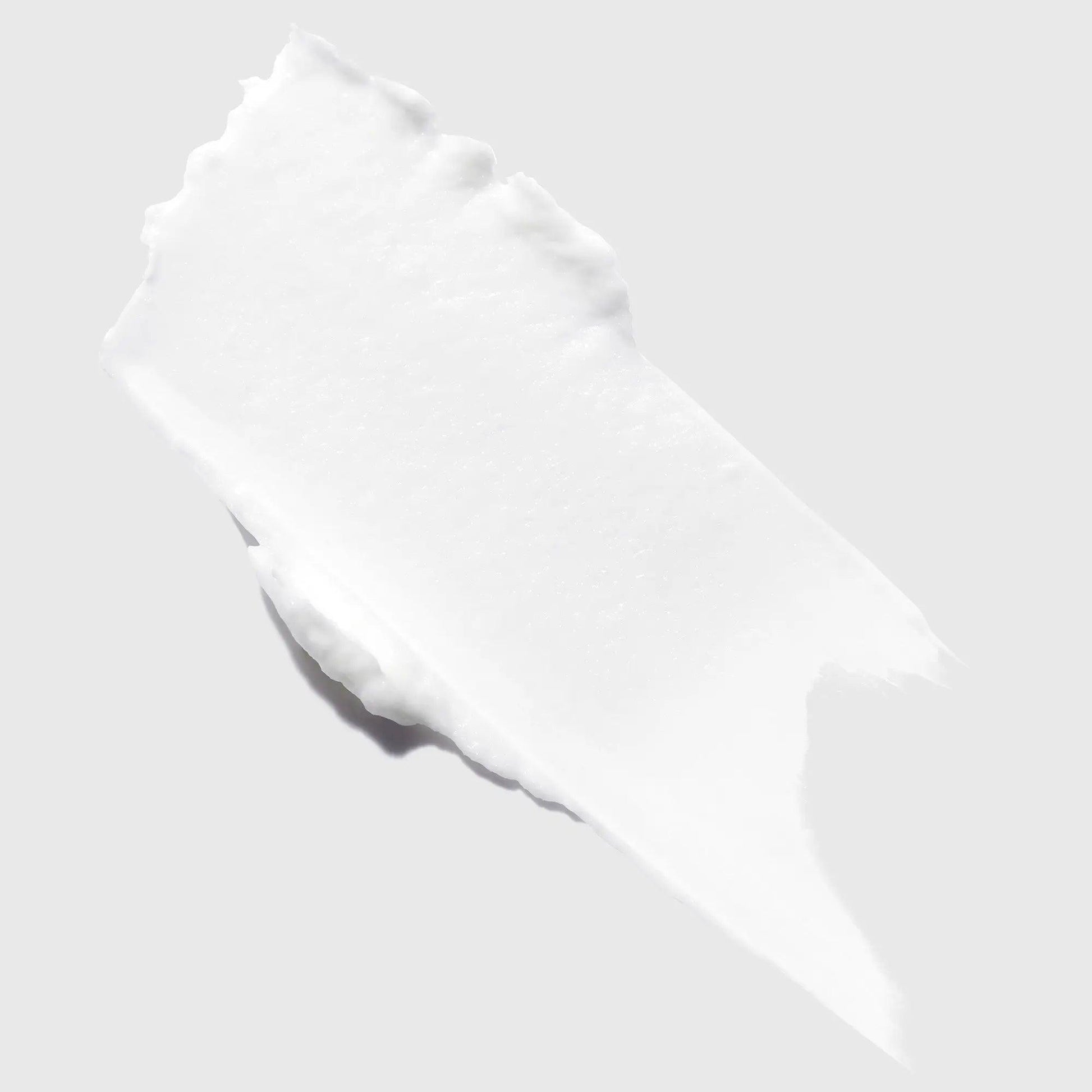 Swatch of Kérastase Genesis Homme Cire d'Épaisseur Texturisante, a smooth white texturizing hair wax for men.