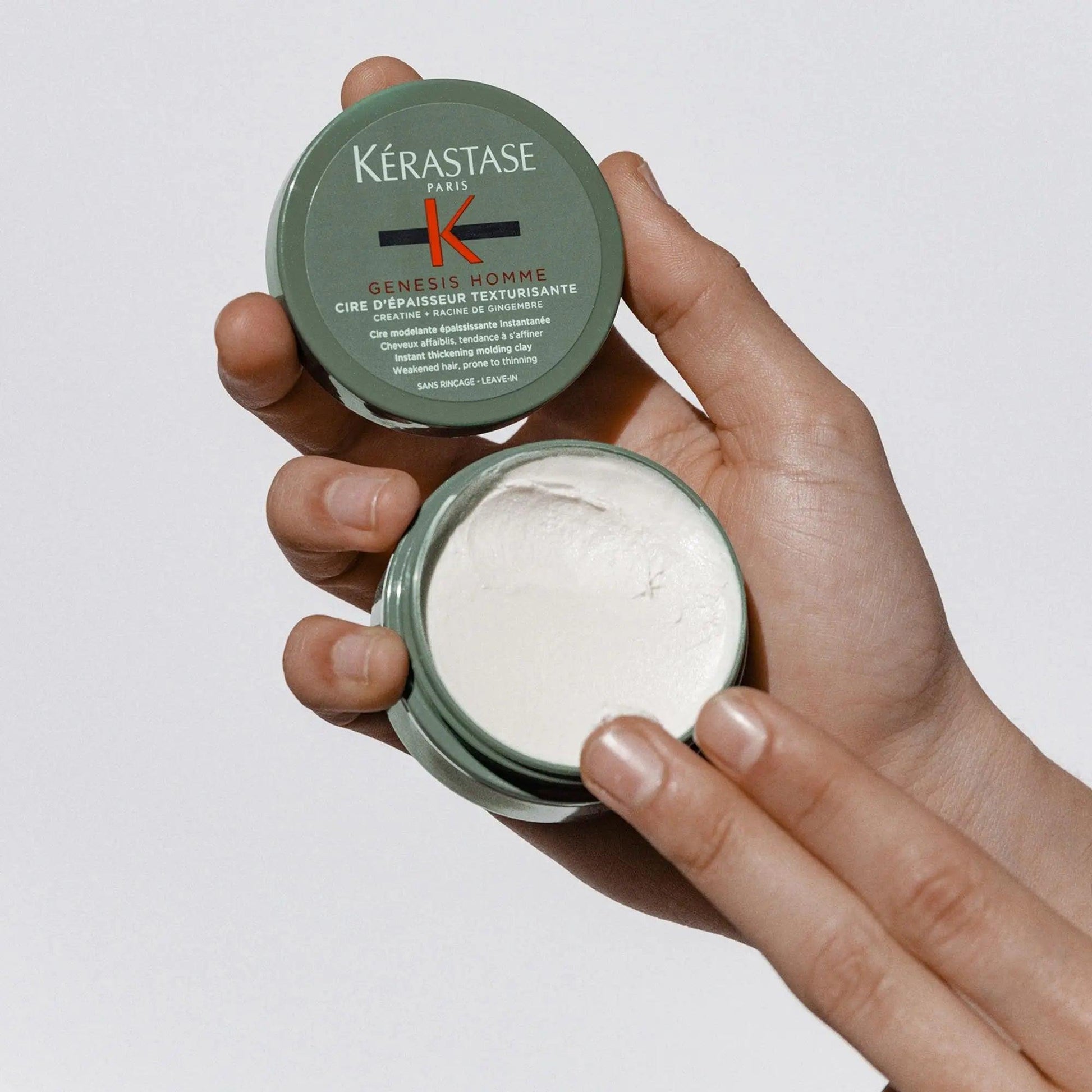 Kérastase Genesis Homme Cire d'Épaisseur Texturisante hair wax in hand, showcasing texture and packaging.