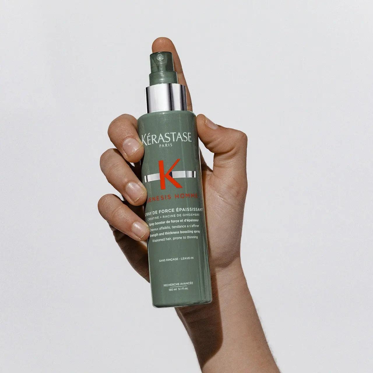 Hand holding Kérastase Genesis Homme Spray de Force Épaississant, a thickening spray for men's thinning hair.