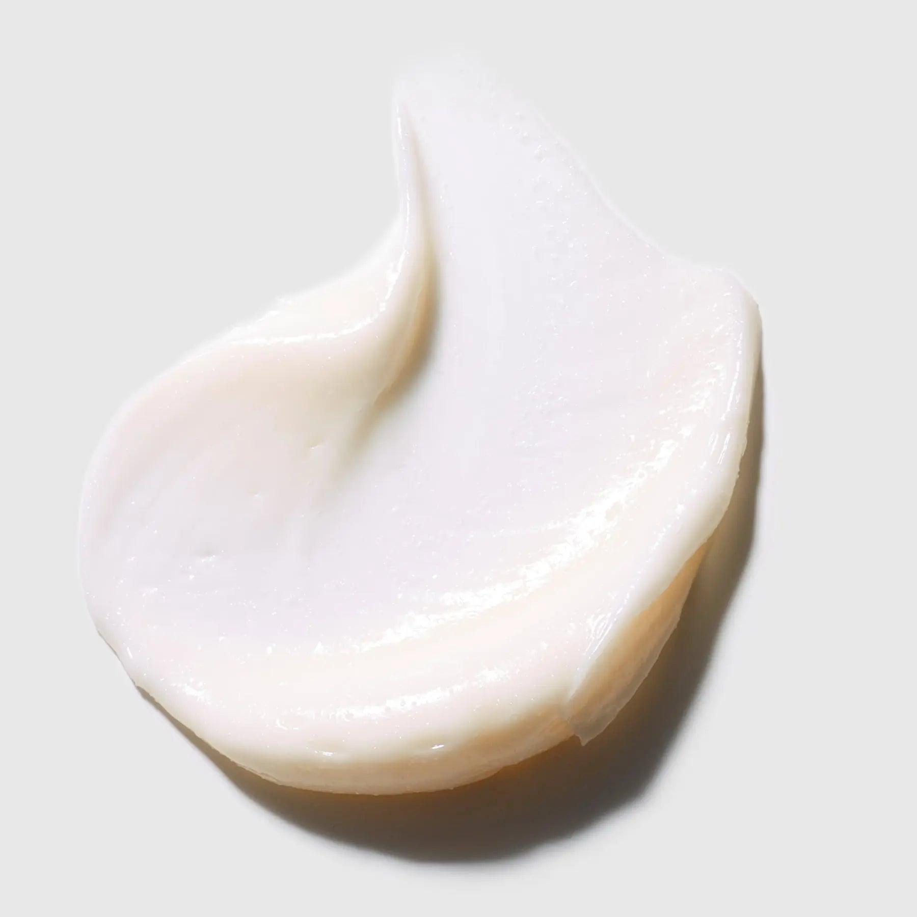 Hydrating white face cream moisturizer sample on gray background.