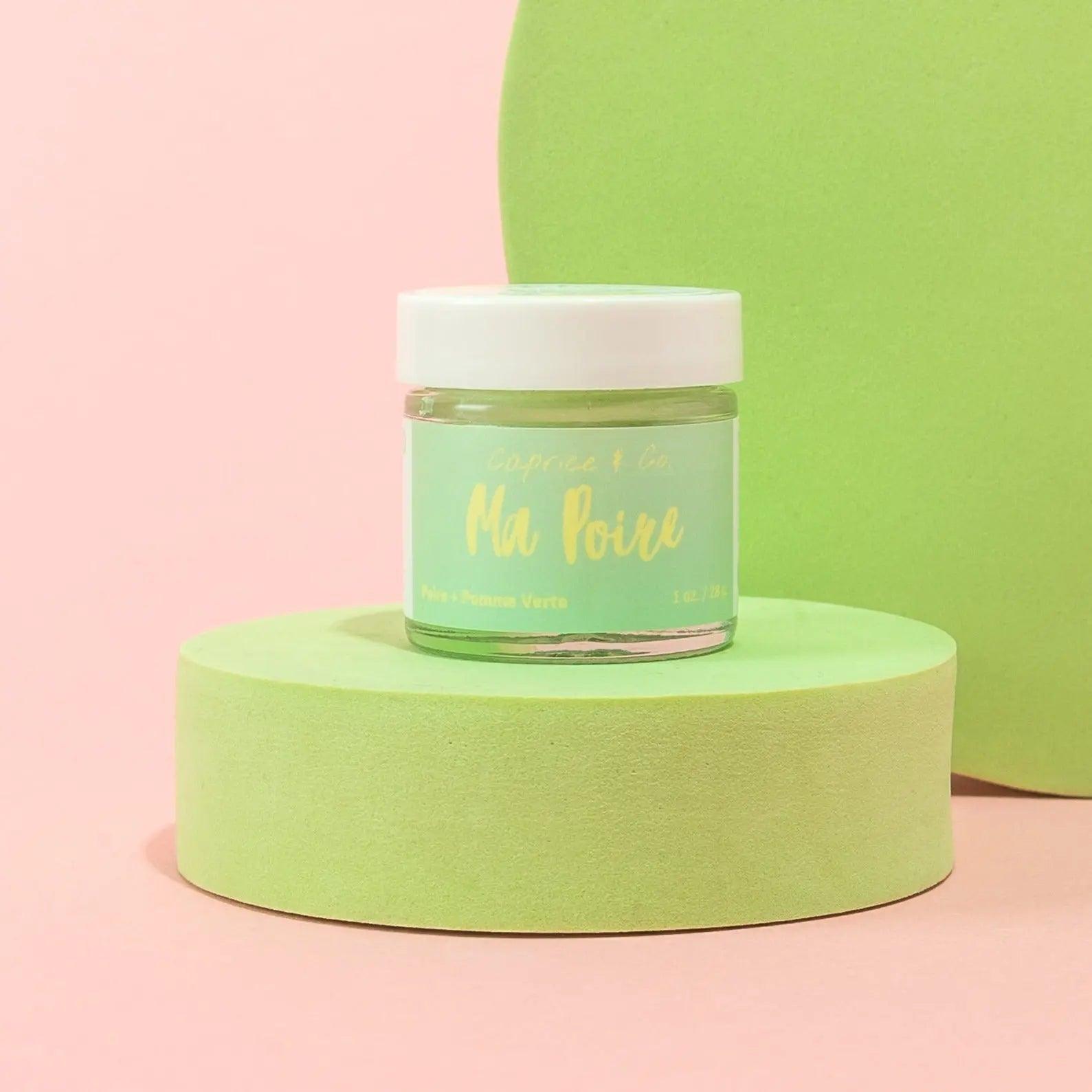 Ma Poire lip scrub jar on pastel background, featuring pear and green apple flavor for gentle lip exfoliation.