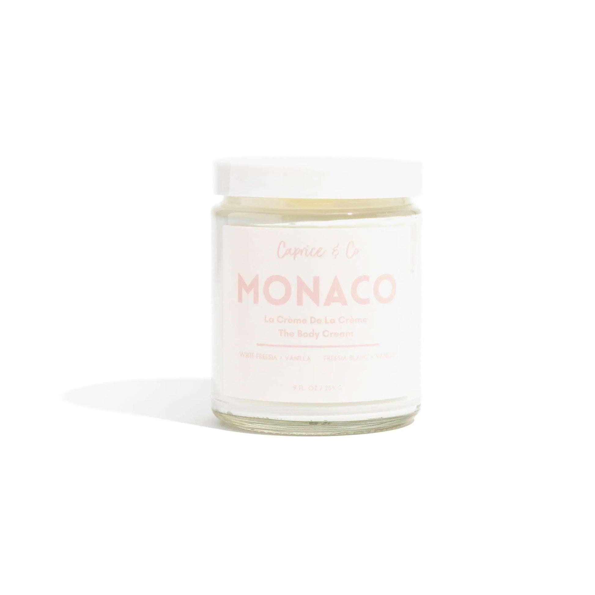 Monaco body cream in a glass jar with a label featuring white freesia and vanilla scent, perfect for deep hydration.