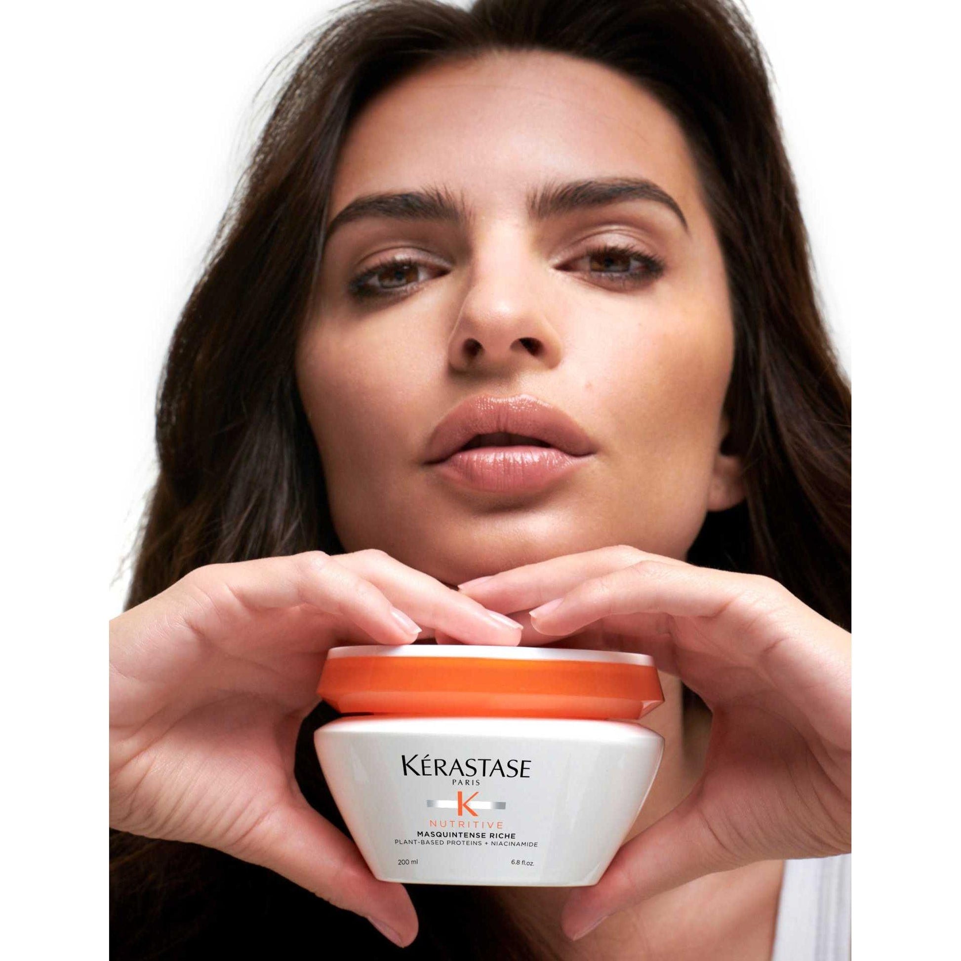 Kérastase Masquintense Riche hair mask held by a model, showcasing its nourishing formula for very dry hair.