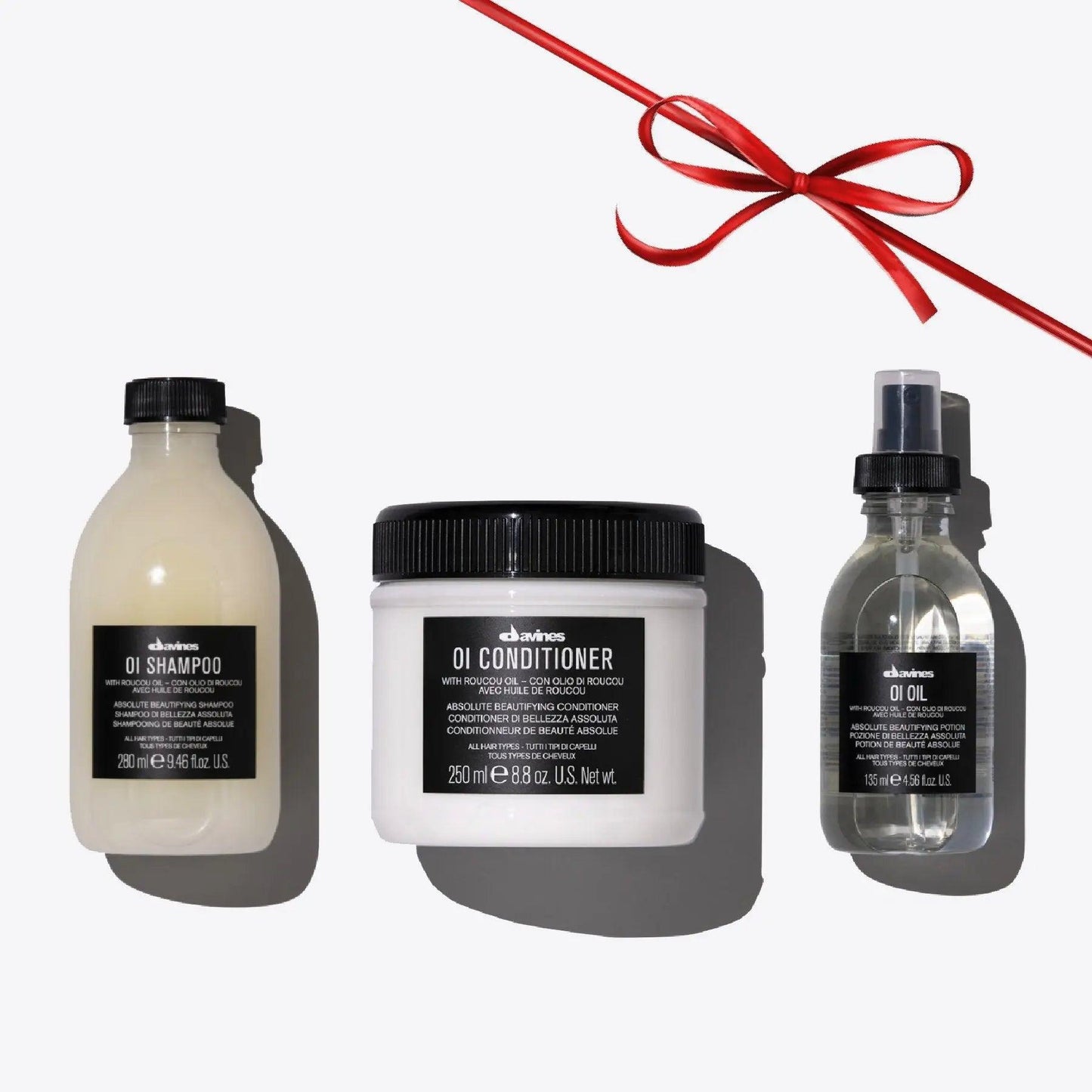 OI Set featuring OI Shampoo, OI Conditioner, and OI Oil for shiny, fragrant hair in elegant packaging.