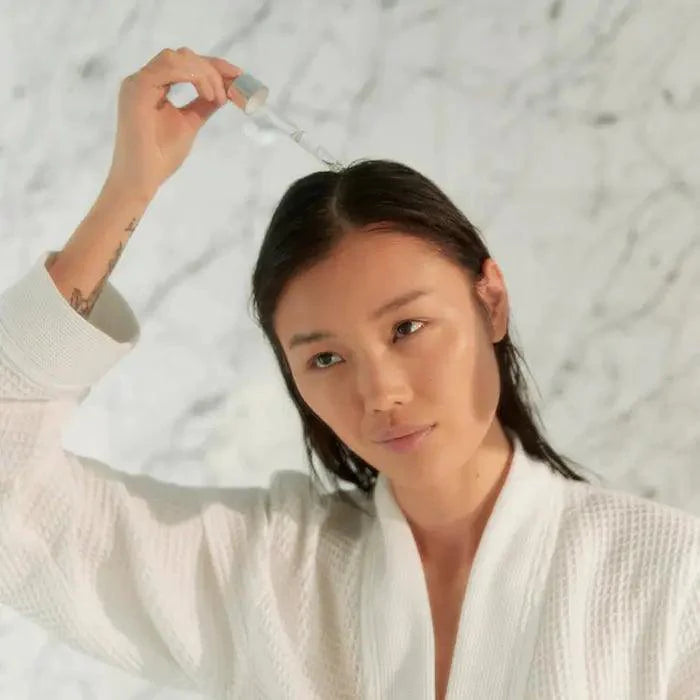 Woman applying Kérastase Potentialiste Hydrating & Soothing Scalp Serum for healthier hair growth.