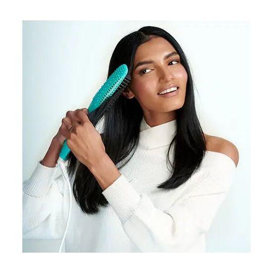 Woman using a Smooth Style Ceramic Heated Brush for sleek, smooth hair in a bright setting.