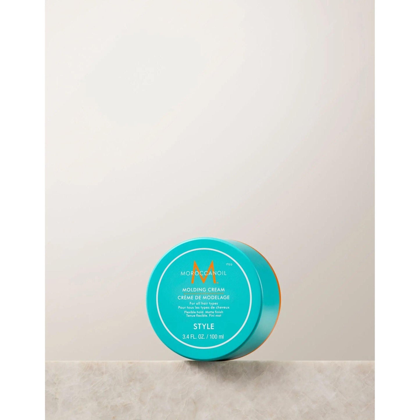 Molding Cream by Moroccanoil in a turquoise container, a fiber-rich texturizing cream for versatile styling.