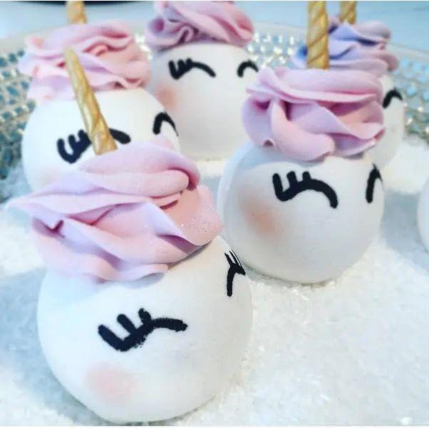 Unicorn-shaped sweet treats with pastel frosting, featuring cute facial expressions and decorative horns.