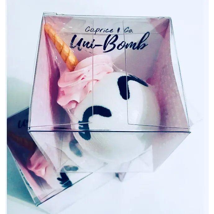 Uni-Bomb XL bath bomb with unicorn design, featuring pink frosting and golden horn in clear packaging.