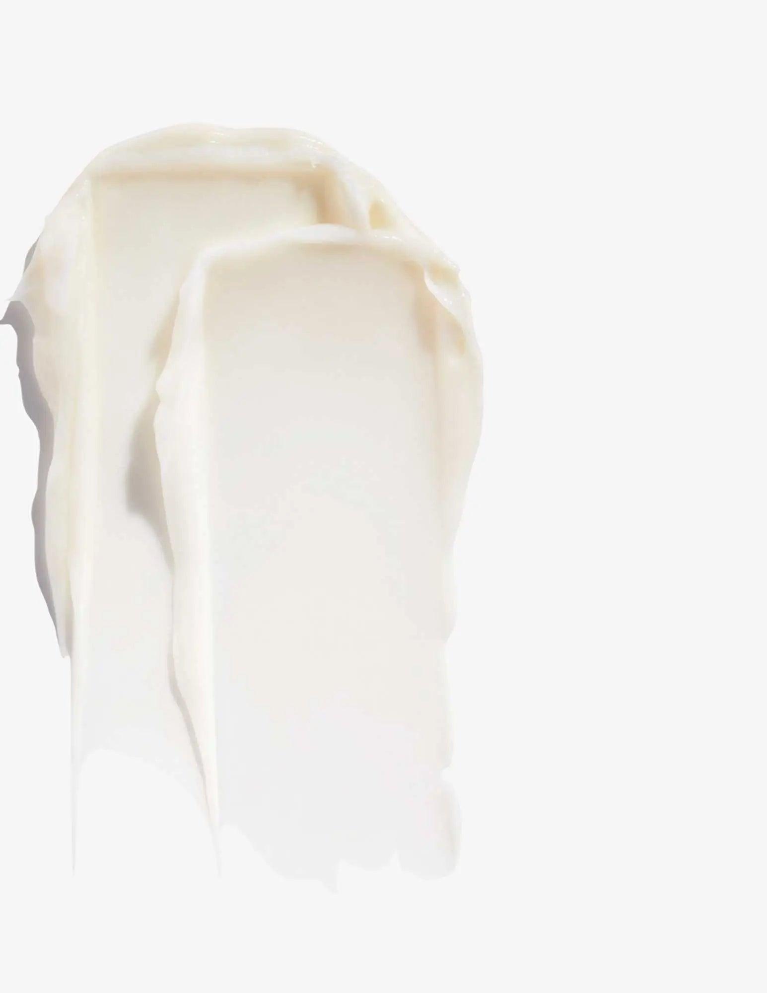 Smooth, creamy texture of Redken Volume Injection Conditioner on a white background, ideal for adding volume to fine hair.