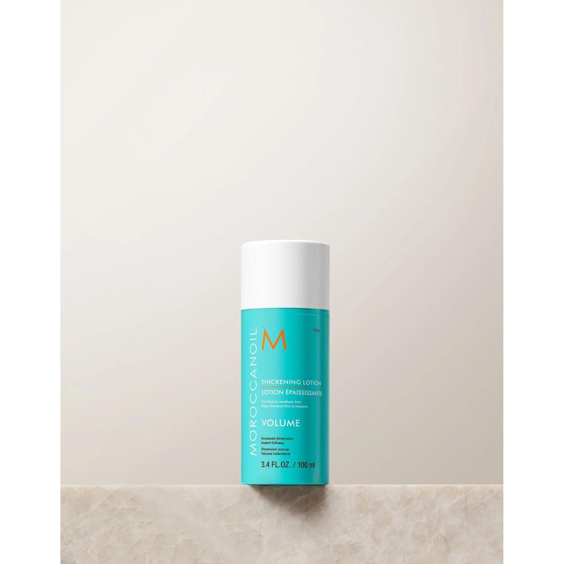 Moroccanoil Volume Thickening Lotion bottle on a neutral background, designed to enhance hair fullness and shine.