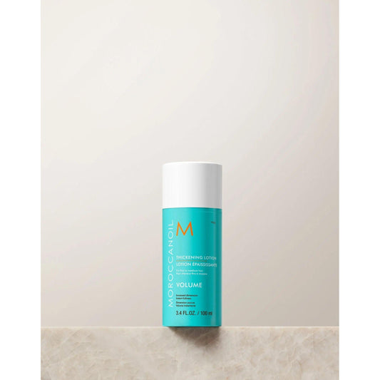 Moroccanoil Volume Thickening Lotion bottle on a neutral background, designed to enhance hair fullness and shine.