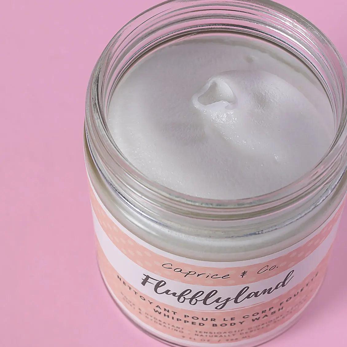 Luxurious whipped soap in a clear jar on a pink background, showcasing its fluffy texture and natural ingredients.