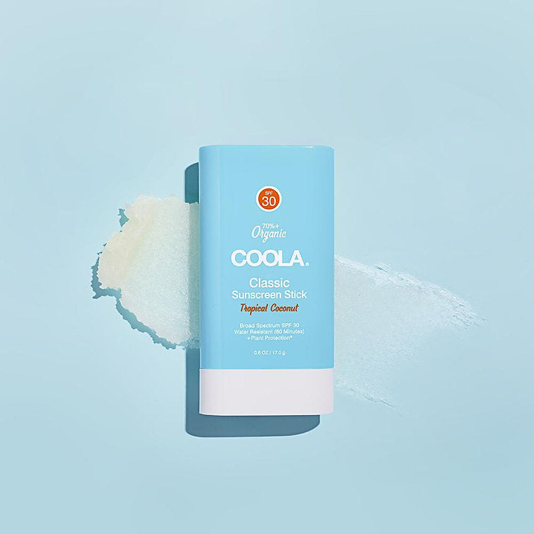 Classic Organic Sunscreen Stick SPF 30 in Tropical Coconut, on a blue background with creamy sunscreen swipe.