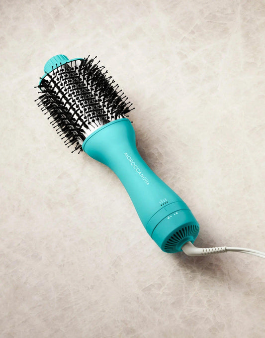 4-in-1 blow-dryer brush in teal color for styling, smoothing, and reducing frizz in hair.