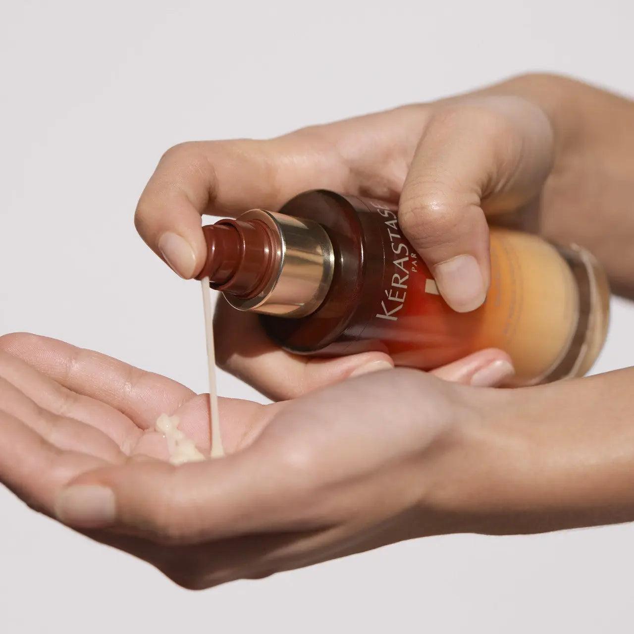 Applying Kerastase hair serum into hands for hair treatment and nourishment