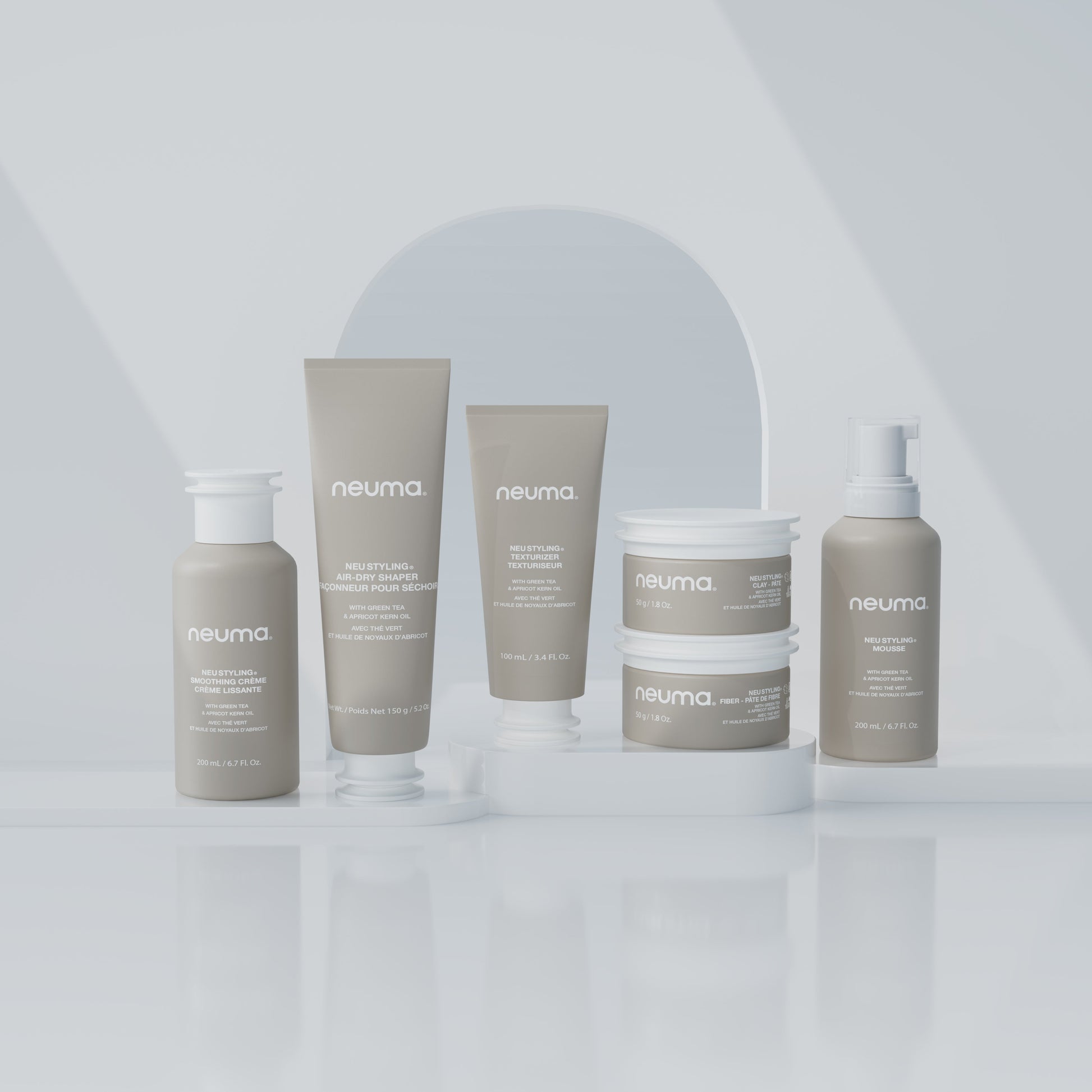 Neuma hair care products displayed on a white surface, featuring mousse, shampoo, and conditioner for enhanced volume and shine.