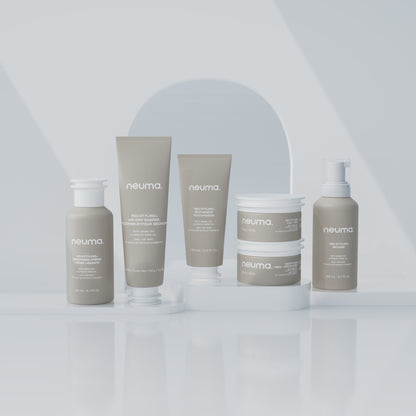 Neuma hair care products displayed on a white surface, featuring mousse, shampoo, and conditioner for enhanced volume and shine.