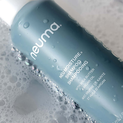 Neuma Moisture Shampoo bottle with bubbles, featuring shea butter and argan oil for hydrating hair care.