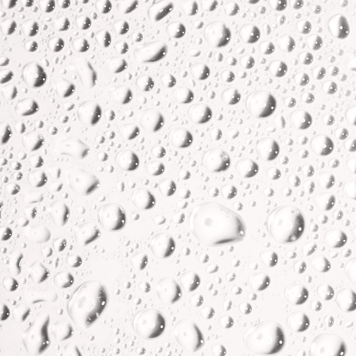 Transparent droplets of water on a smooth surface, reflecting light and creating a fresh, clean ambiance.
