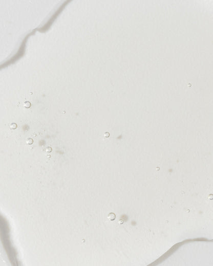 Close-up of GrenzCine Serum showing a clear, gel-like texture with tiny bubbles, highlighting its moisturizing properties.