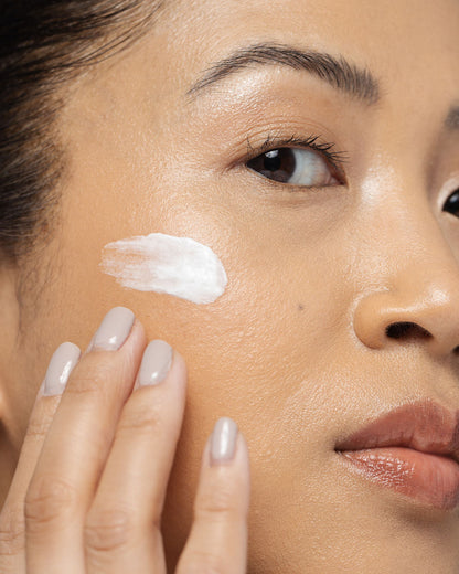 Woman applying Vivier Nightly Age-Defying Moisturizer on her face, highlighting its hydrating and anti-aging benefits.
