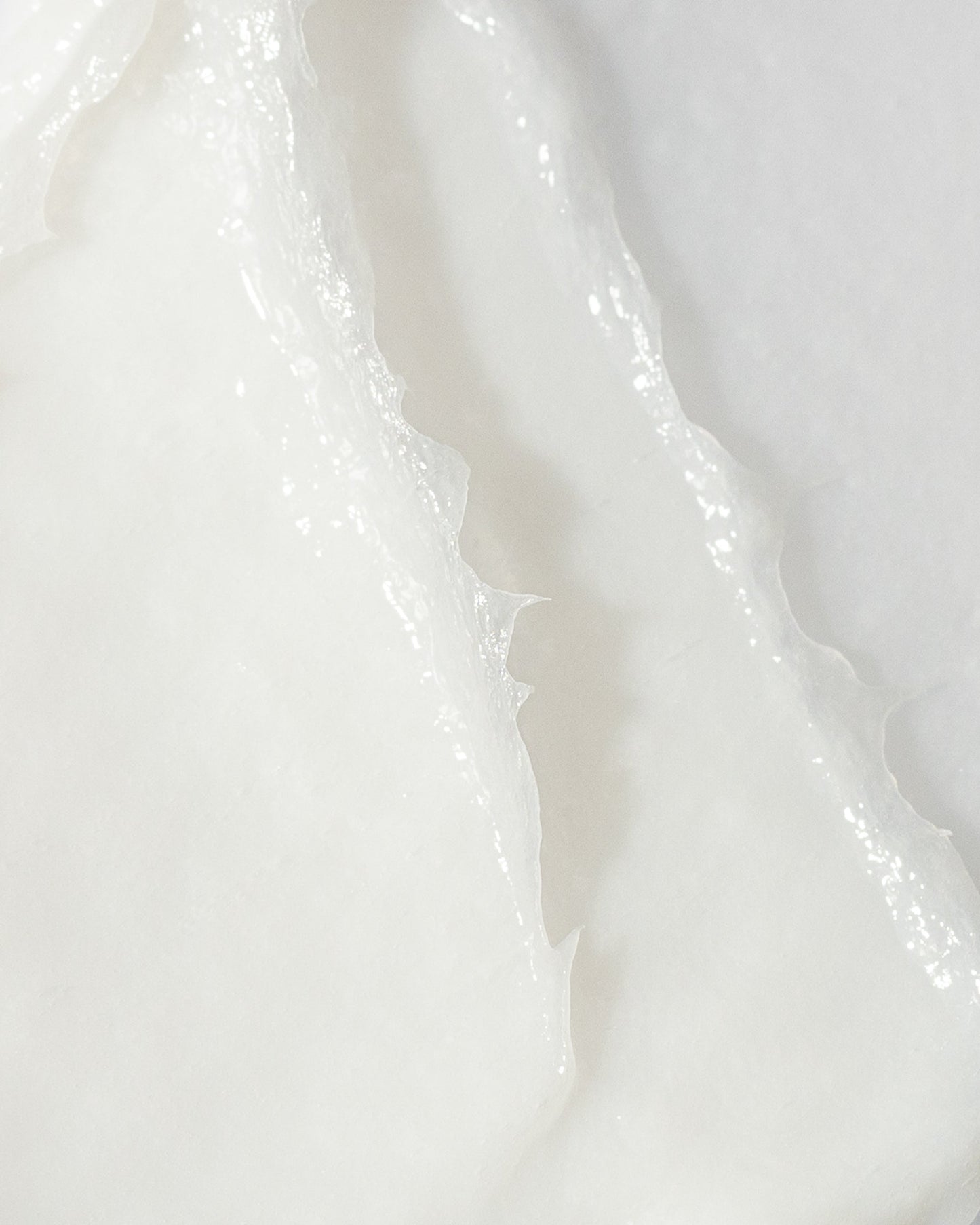 Close-up of smooth, white skin brightening cream texture, highlighting its hydrating and brightening properties.