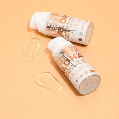 Two bottles of Aloha Aloe + Lotus Soothing Gel with gel application on a peach background, highlighting its hydrating properties.