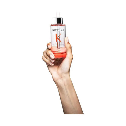 Hand holding Kerastase hair serum bottle, premium hair care product for smooth and healthy hair, popular hair treatment solution.