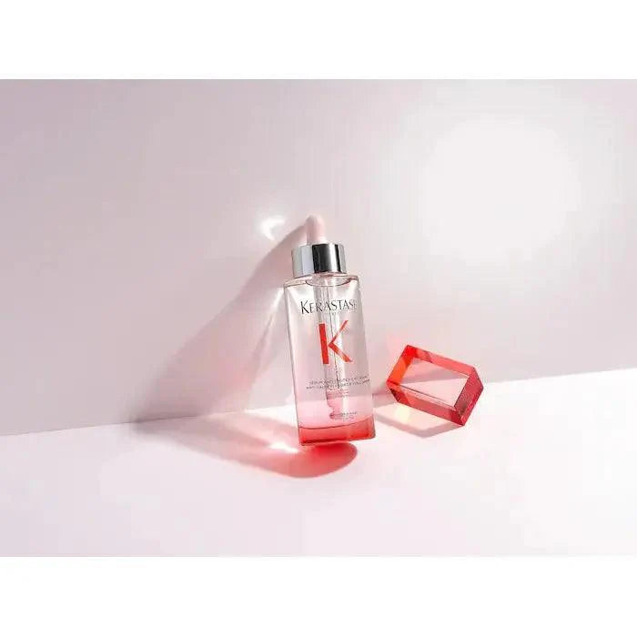 Kerastase hair serum bottle with red accent and dropper, displayed elegantly on white surface with a reflective red crystal块