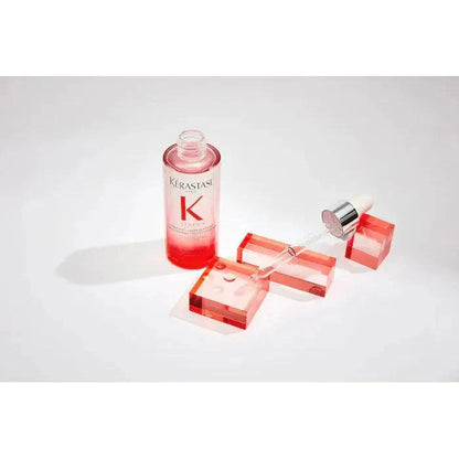 Kérastase hair serum bottle with dropper and red blocks on white background