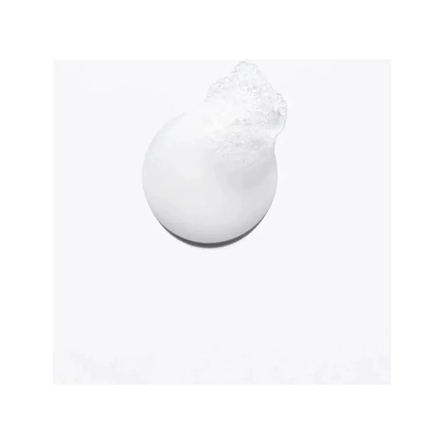 Close-up of white foam cleanser on a light background.