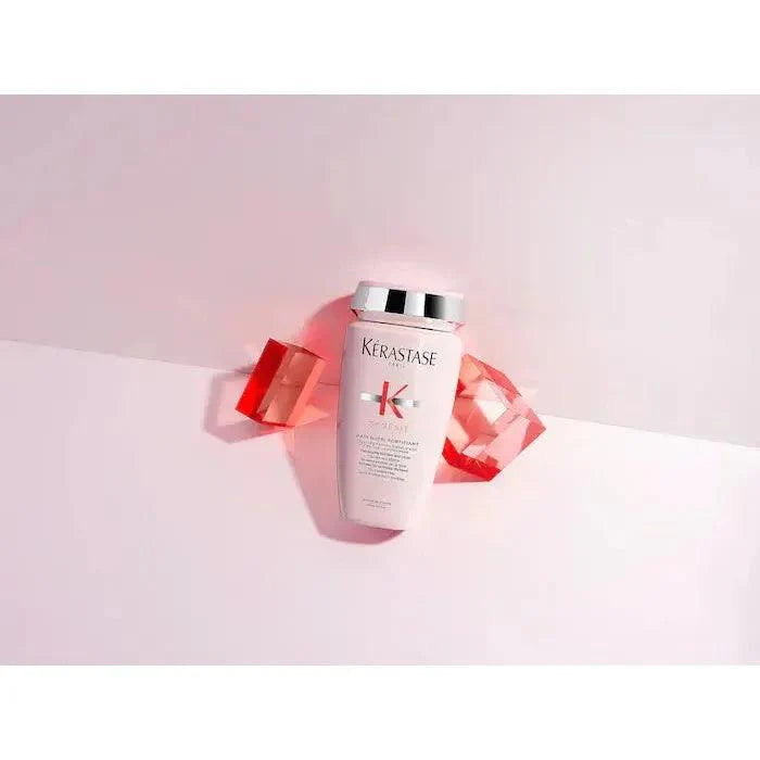 Kerastase hair care product surrounded by red gems on a pink background