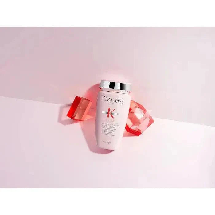 Kerastase hair care product surrounded by red gems on a pink background