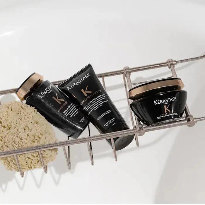Kérastase haircare products in a bath rack, including shampoo, conditioner, and hair mask, for luxurious hair treatment and rejuvenation.