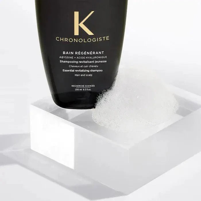Kérastase Chronologiste Bain Régénérant Shampoo for Hair and Scalp on a modern white surface with foam bubbles